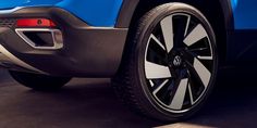 the rear end of a blue car with black spokes