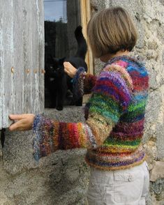 a little boy that is standing in front of a door with a cat behind him