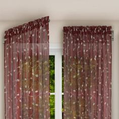 an open window with red curtains in front of it and trees outside the windowsill