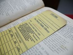 an open book with a yellow ticket sitting on top of it