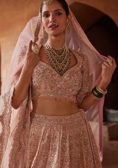 Editor's Note Capture romance in our blush pink raw silk lehenga choli set. The net dupatta, belt, and choli are adorned with exquisite appliqué work, enhanced by delicate dabka, beadwork, and crystals. This creation blends grace with intricacy, offering a versatile and enchanting outfit that's perfect for any special occasion. Note: Veil is for styling purposes only Fabric: Raw silk and net Color: Pink Components: Lehenga, blouse, belt and dupatta Occasion: Wedding Note: Product colour may slig Beaded Lehenga, Dupatta For Lehenga, Gold Bridal Lehenga, Bandhej Dupatta, Pink Bridal Lehenga, Net Veil, Satin Lehenga, Net Lehenga Choli, Gold Lehenga