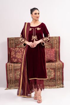 A deep red velvet suit with traditionally inspired full hand embroidery and emphasized with kora and nakshi work. Paired with a khadi silk dupatta with gota work lines on it and a velvet pajama with silk work on the bottom.3-piece suitReady-to-wear Designer Red Anarkali Set With Embroidered Border, Red Anarkali Set With Embroidered Border For Designer Occasions, Red Raw Silk Lawn Suit With Dabka Work, Red Lawn Suit With Dabka Work In Raw Silk, Designer Red Embroidered Border Set, Red Raw Silk Lawn Suit With Zari Work, Red Lawn Suit With Zari Work In Raw Silk, Red Sharara With Naqshi For Eid, Elegant Red Anarkali Set With Naqshi Detailing