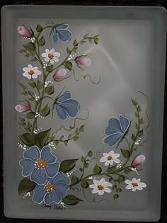 an image of flowers and leaves on a glass plate in the shape of a letter