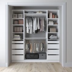 an open closet with white drawers and clothes hanging on the shelves, along with other items