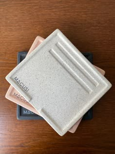 three ceramic coasters sitting on top of a wooden table with the word maccus printed on them