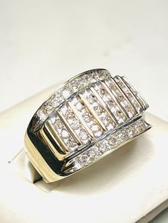 a diamond ring sitting on top of a white plate with a silver band and two rows of diamonds in the middle