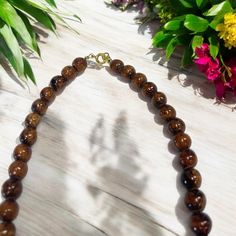 This necklace boasts a clasp closure, showcasing the exquisite natural appearance of Hawaiian Koa Wood, embodied by its 8mm beads. With sizes available in 16, 18, and 20 inches, this popular piece is renowned for its authentic and timeless allure. Material: Koa Wood Bead Size: 8mm Clasp Closing Size: 16 inch | 18 inch | 20 inch Brown Necklace With Round Beads And Lobster Clasp, Elegant Brown Necklace With 8mm Beads, Classic Necklace With 8mm Beads For Gift, Classic 8mm Beads Necklace For Gifts, Classic 8mm Bead Necklaces As Gifts, Classic Round Beaded Necklaces As Gift, Classic 8mm Beaded Necklaces As Gift, Classic 8mm Bead Necklaces Perfect For Gifts, Elegant Brown Necklace With Lobster Clasp