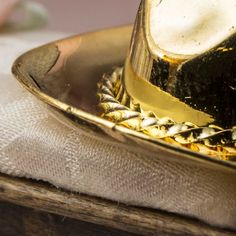 Miniature Gold Brass Cowboy Hat. Whether you are a cowboy or cowgirl, this Miniature Brass Cowboy Hat guarantees to bring a smile to the western lover in all of us!    Let this tiny accessory reside in your wee dollhouse world or sit upon your personal life-size desk! Use as a special western themed party favor. Add it to your fairy garden, terrarium, or dioramas.    Miniature collectors and crafters, alike, will appreciate its detailed features, and antiquated finish.    Dollhouse miniatures ar Western Gold Fedora With Short Brim, Western Style Gold Fedora With Short Brim, Western Style Gold Fedora With Flat Brim, Gold Fedora Hat For Rodeo, Gold Flat Brim Hat For Rodeo, Gold Short Brim Hats For Country Events, Gold Brimmed Hat For Rodeo, Gold Fedora Western Hat, Gold Western Fedora Hat