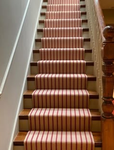 the stairs are lined with red and white striped carpet