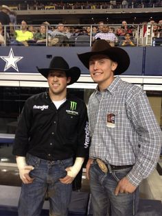 two men standing next to each other wearing cowboy hats