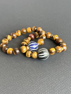 Tigers Eye Unisex Bracelet With Black & White Java Focal Bead - Etsy Adjustable Wooden Beads Bracelet, Artisan Wooden Beads Stretch Bracelet, Handmade Stretch Bracelet With Round Beads For Everyday, Artisan Hand Wrapped Black Bracelets, Everyday Handmade Stretch Bracelet With Round Beads, Artisan Hand Wrapped Black Bracelet, Artisan Hand-wrapped Black Bracelet, Artisan Brown Bracelets With Gemstone Beads, Artisan Brown Bracelet With Gemstone Beads