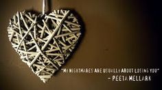 a heart made out of sticks hanging on a wall with a quote written below it