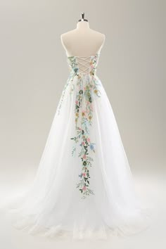 a white wedding dress with flowers on it