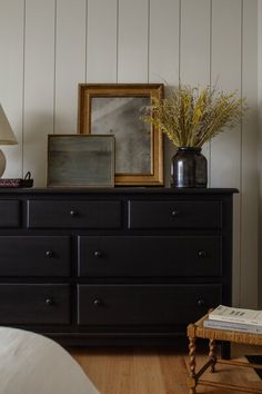 a bedroom with a dresser and pictures on the wall