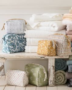 towels stacked on top of each other in front of a wooden bench