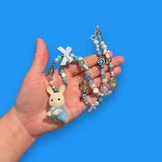 Bring some whimsy to your outfit with our Critter Bead Necklace, adorned with a charming Calico Critter. Each necklace is one-of-a-kind, handmade in Manchester, UK with varying colors and beads for a unique touch. Elastic thread and a clasp closure make it easy to wear. Cute Blue Necklace For Gift, Playful Handmade Adjustable Charm Necklaces, Playful Handmade Blue Beaded Necklaces, Handmade Whimsical Blue Beaded Necklaces, Whimsical Handmade Blue Beaded Necklaces, Cute Handmade Adjustable Necklace, Whimsical White Handmade Beaded Necklace, Whimsical Blue Charm Necklace As Gift, Whimsical Blue Charm Necklace For Gift