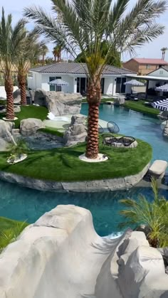 an artificial pool surrounded by palm trees and rocks