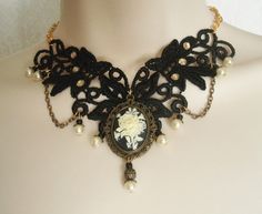 "This beautiful necklace has an antique gold filigree pendant with rose cameo setting, pearl beads, gold plated bead caps, seed beads, metal chain and black lace with rhinestone accents. It is 13\" long adjustable to 17\" long. Lobster clasp." Gothic Filigree Necklace For Wedding, Gothic Filigree Wedding Necklace, Gothic Wedding Necklace With Filigree Detail, Gothic Filigree Pendant Jewelry, Bronze Gothic Jewelry For Gift, Gothic Filigree Necklaces For Gifts, Gothic Gold Pendant Necklace, Gothic Handmade Formal Necklace, Handmade Gothic Necklaces For Formal Occasions