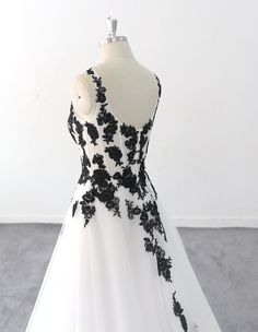 a black and white wedding dress on a mannequin headdress in front of a white wall