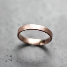 a close up view of a wedding ring on a table with the surface in the background