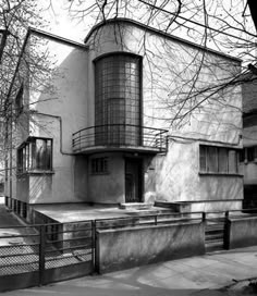 black and white photograph of the exterior of a building with stairs leading up to it