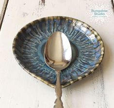 a spoon sitting on top of a blue and white plate