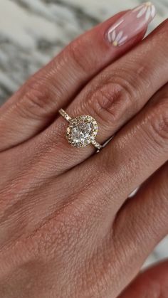 a woman's hand with a ring on her finger and an oval shaped diamond in the middle