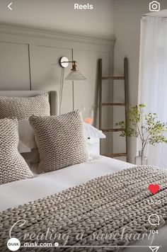 a bed with white linens and pillows in a bedroom next to a window that has a red heart on it