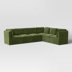 a green sectional couch sitting on top of a white floor