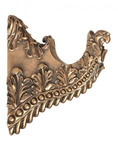 an ornate brass metal hook with leaves on it's side and a white background