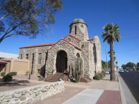 an old stone church with palm trees in the foreground