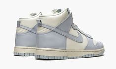 The Women’s Nike Dunk High “Football Grey” is the women’s sizing of the all-time classic high-top shoe that was released by Nike in early January 2021.  The “Football Grey” doesn’t have any ties to a specific football team, but instead references the shade of grey used on its design.  Along with the interesting shade, an elegant mixture of Sail and Pale Ivory combine to form a stately look for the Nike Dunk High.  A cream colored leather appears on the perforated toe, mid-panel, collar, and heel High Top Shoe, Nike Brand, Nike Dunk High, Dunk High, Womens Football, Grey Shoes, Colored Leather, Black Metallic, Nike Dunk