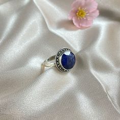 Aurora is a beautiful ring featuring a smooth round cushion cut Lapis Lazuli nestled in a finely detailed, sterling silver frame. Aurora is the perfect pick-me-up when you need that extra sparkle with it's ethereal, vintage-inspired design in silver. Authentic Sivalya Lapis Lazuli Lapis Lazuli: Inner Power - Wisdom - Manifestation Hallmarked Metal: 925 Sterling Silver Gemstone Size: 10mm x 10mm Cut: Round Shaped Smooth Cabochon Classic Sapphire Cabochon Rings, Timeless Cabochon Sapphire Ring Gift, Timeless Round Cabochon Sapphire Ring, Timeless Sapphire Ring Gift, Timeless Gift Sapphire Cabochon Ring, Sterling Silver Timeless Birthstone Ring, Timeless Sterling Silver Birthstone Ring With Gemstone, Classic Open Sapphire Ring, Classic Sapphire Open Ring