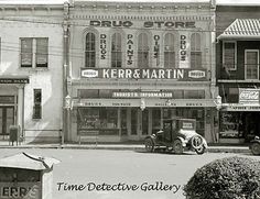 an old black and white photo of cars parked in front of storefronts