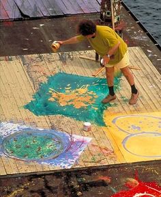 a man is painting on the ground with chalk