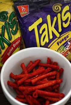 a bowl filled with cheetos next to two bags of tater tots