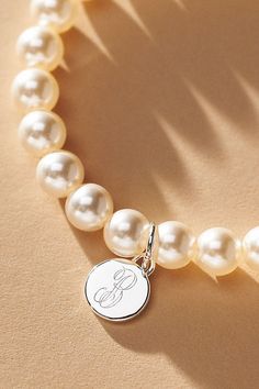 Elevate your special day with the exquisite Pearl Monogram Bracelet, a touch of personalization. Whether you opt for the initial of your cherished partner or choose to commemorate a beloved one, let this bracelet be a timeless symbol of connection and closeness. | Pearl Monogram Pearl Bracelet by Anthropologie in Alphabet, Women's, Gold/Plated Brass/Glass Mother Of The Bride Bracelet, Classic Personalized Initials Bracelet, Classic White Jewelry With Initials, Elegant White Monogram Jewelry, Elegant Anniversary Charm Bracelet, Elegant Charm Bracelet For Anniversary, Personalized Sterling Silver Initials Bracelet, Sterling Silver Initials Bracelet For Personalized Gift, Elegant Silver Name Bracelet With Round Beads