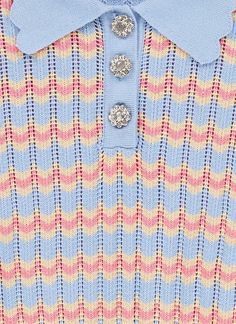 a blue and pink striped sweater with buttons on the collar is seen in this image