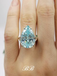 Made to order. Please allow up to 3 weeks for the production of your ring. This listing is for a 925 non-plated sterling silver solitaire ring with a light Paraiba blue pear cut cubic zirconia gemstone. Gem Type: Lab Created Cubic Zirconia Diamond Shape: Natural Pear Cut Size: 18x12mm Weight: 11 Carat Approximately Color: Light Paraiba Blue Quality: 5A Hardness: 8.5 Mohs Did you know there are different grades of cubic zirconia? (A - 6A) The higher the grade, the better the material, polish and more accurate the cut. Most cubic zirconia jewelry is made with grade 3A cubic zirconias. 3A (AAA) is a good and popular quality because of it's relatively cheap price. 3A stones are cut and polished faster so less care is taken during production. 6A quality is the highest quality, perfectly structu Silver Teardrop Gia Certified Ring, Teardrop Aquamarine Jewelry For Anniversary, Gia Certified Silver Teardrop Ring, Blue Pear-shaped Brilliant Cut Jewelry, Pear-shaped Blue Brilliant Cut Jewelry, Luxury Blue Teardrop Rings, Blue Pear Shaped Jewelry With Prong Setting, Blue Pear-shaped Jewelry With Prong Setting, Blue Pear Shaped Prong Set Jewelry