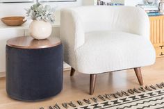 a white chair sitting next to a wooden table on top of a hard wood floor