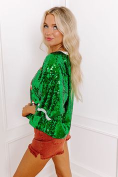 - Be ready for a game day glow-up with this shimmering sequined top! With an adorable football design and a relaxed fit it has a sporty feel with a stylish twist. Shine like the stadium lights with this trendy piece of gameday gear. - Fully lined shimmering sequin material - A white and orange hued football pattern on the front - A crew cut neckline - Short sleeves with jersey-style accent stripes - A relaxed silhouette that ends in a straight hemline - This piece is perfect for Baylor fans! Mea Green Sequined Long Sleeve Top, Green Long Sleeve Sequin Top, Green Sequin Tops For Fall, Green Top For Night Out Party Season, Green Sequined Tops For Spring, Green Crew Neck Top For Night Out, Day Glow, Crew Cuts, Football Design