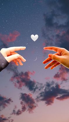 two hands reaching out towards each other with a heart shaped object in the sky behind them