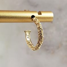 Elevate your style with our Minimalist Vintage Gold Hoop Earrings. These small, lightweight earrings feature a unique etched design, perfect for any occasion. The shimmering gold finish adds a touch of antique charm, while the secure huggie style ensures a comfortable fit. Ideal as a unique gift or a stylish addition to your jewelry collection. ✓ Measures 15 mm / 9/16 in diameter✓ Weight: 2.3 grams✓ Secure push back ensures all-day wear✓ Unique filigree scrollwork design for a standout look✓ Shi