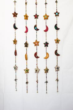 a group of stars and crescents hanging from strings on a white wall next to each other