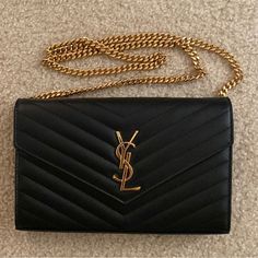 Like Brand New. Used Only A Few Times. No Damages/Scratches. Black With Gold Hardware And Gold Chain. Sticker Protector On Zipper In Place. Comes With Dust Bag, Box, And Card. Ysl Black Purse, Ysl Clutch Bag, Ysl Chain Wallet, Black Purse With Gold Chain, Ysl Chain, Chain Sticker, Black And Gold Purse, Ysl Wallet On Chain, Ysl Crossbody Bag