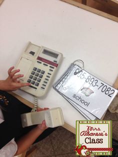 a person sitting at a table with an old phone and calculator in front of them