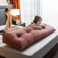 a woman laying on top of a futon bed