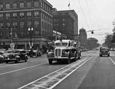 an old photo of cars driving down the street