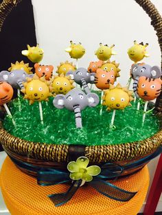 a basket filled with lots of little yellow and gray animals on top of green grass