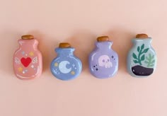 three small vases with plants and animals painted on them are lined up against a pink background